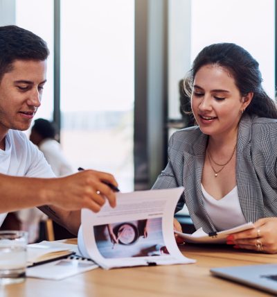 Shot of two businesspeople going through paperwork together in an office.